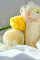 Scrub, loofah washcloth and organic sea sponge on the towel. photo