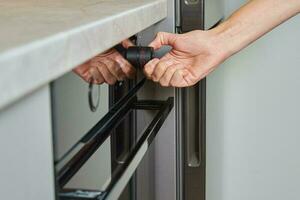 Female choosing program on electric oven panel photo