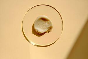 Facial peeling drop swatch on a beige background. photo