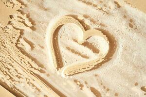 Photo of cosmetic foam or soap with a heart drawn on the foam.