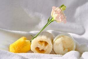 Scrub, loofah washcloth and organic sea sponge on the towel. photo