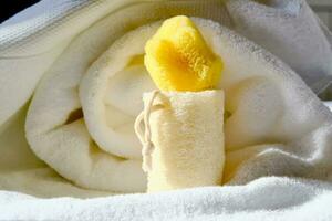 Loofah washcloth and organic sea sponge on the background of towel. photo