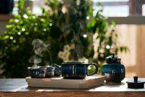 Tea set of deep blue color on a background of greenery. photo