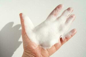 Photo of the texture of cosmetic foam on the hand.