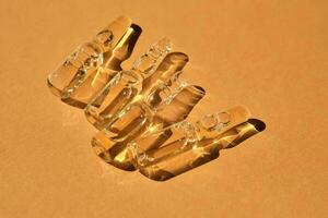 Glass ampoules on a beige orange background. photo