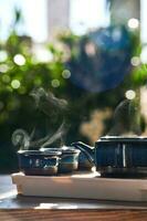Tea set of deep blue color on a background of greenery. photo