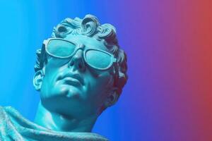 Gypsum statue in sunglasses on colored abstract background. photo