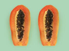 Half of ripe papaya fruit with seeds on a color background. Appetizing tropical fruit photo