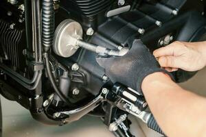 mecánico utilizar petróleo filtrar llave inglesa eliminación herramienta en motocicleta a garaje ,concepto de motocicleta mantenimiento y reparar. selectivo atención foto