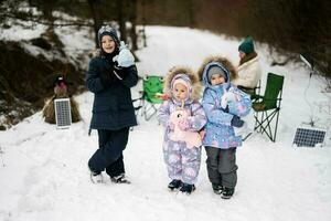 Children in winter forest on a picnic with stuffed toys at hands. photo