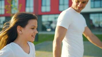 pappa och dotter promenad runt om deras område på solnedgång. barn innehar fars hand video