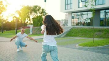 figlia corre per papà e abbracci lui. padre scelte su il bambino nel il suo braccia video