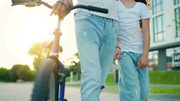 papá es enseñando hija cómo a paseo bicicleta a puesta de sol. lento movimiento video