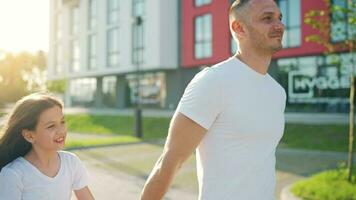 papa et fille marcher autour leur zone à le coucher du soleil. enfant détient du père main video