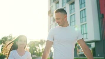 papa et fille marcher autour leur zone à le coucher du soleil. enfant détient du père main video