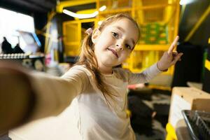 Preschooler girl making selfie at children play center. photo