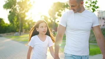 papà e figlia camminare in giro loro la zona a tramonto. bambino detiene Il padre di mano video