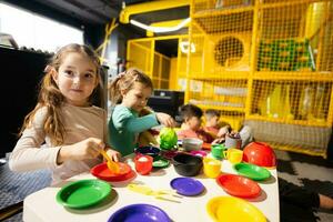 Two sisrers playing in kids kitchen at children play center. photo