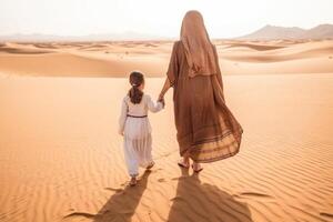 Mother and daughter walking together in the desert. . photo