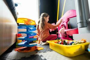 Preschooler girl child in day care center playing with dolls toys. photo