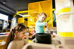 Two sisrers playing in kids kitchen at children play center. photo