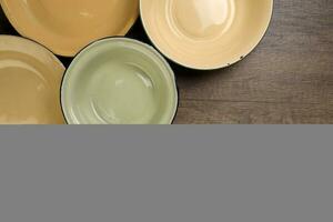 Enamel tin metal food plate pot bowl retro vintage tableware dinnerware on rustic wood background top view photo