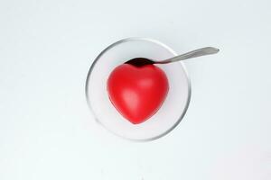 transparent glass bowl spoon with three dimension 3d red hart shape symbol inside on white background copy text space top view photo