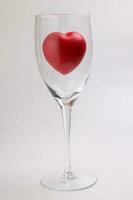 transparent wine glass with three dimension 3d red hart symbol inside on white background copy text space photo
