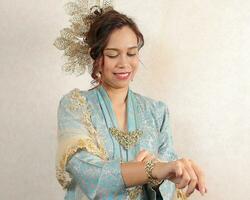 Beautiful young woman wearing Mahsuri style Baju Kebaya Labuh traditional malay Malaysian dress fashion photo