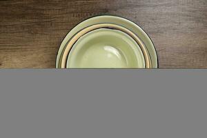 Enamel tin metal food plate pot bowl retro vintage tableware dinnerware on rustic wood background top view photo