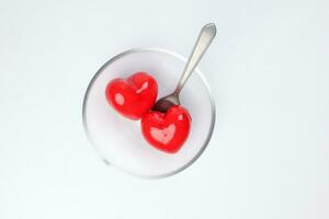 transparent glass bowl spoon with three dimension 3d red hart shape symbol inside on white background copy text space top view photo