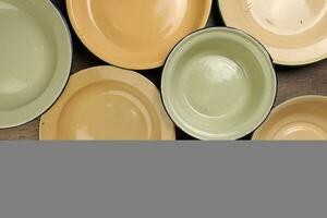 Enamel tin metal food plate pot bowl retro vintage tableware dinnerware on rustic wood background top view photo