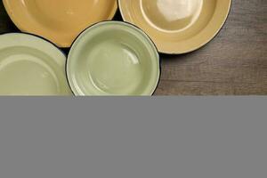 Enamel tin metal food plate pot bowl retro vintage tableware dinnerware on rustic wood background top view photo