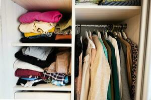 Closet with different clothes in wardrobe photo