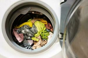 Lavado máquina con un lote de sucio ropa en el lavandería habitación foto