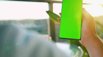 donna seduta nel un' bar e utilizzando smartphone con verde modello schermo nel verticale modalità. ragazza navigazione Internet video