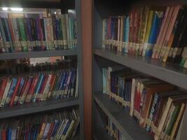 Bookshelves in the library. Large bookcase with lots of books. Library or shop with bookcases. Cozy book background. Bookish, bookstore, bookshop. photo