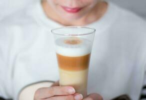 Woman holding a cup Coffee latte milk froth the hot drink photo