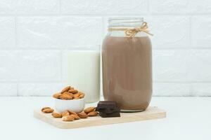 Milk Chocolate and Almonds in a glass on a white background photo