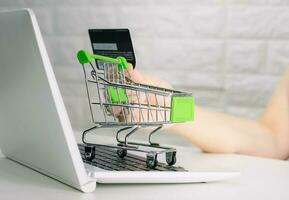 Hands holding credit card on the keyboard online shopping on laptop photo