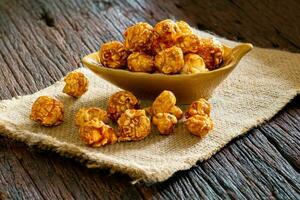 caramelo palomitas de maiz en un taza en de madera piso foto