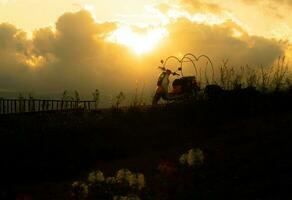 silhouette of motorcycle on mountain view with sunlight photo