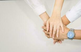 hands showing unity and teamwork clasped cooperation top view of people putting their hands photo