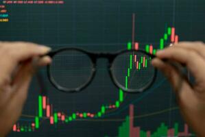 Hand holding glasses trade financial stocks and investments photo