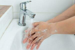 adults wash their hands with hand soap to prevent infection and viruses photo