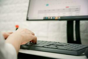 el mano de un mujer de negocios es trabajando con un computadora foto