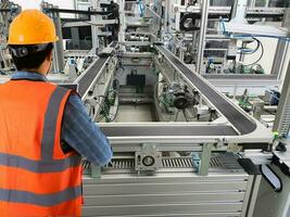 Engineers use technology to control production machinery in industrial plants. photo