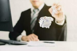 businessman emotions and fail concept crumpled paper on table with, unhappy no idea to thinking throwing papers in office photo