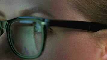 Woman in glasses looking on the monitor and and working with charts and analytics. The monitor screen is reflected in the glasses. video