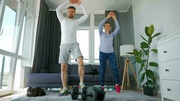 Caucasian couple doing cardio training at home in cozy bright room video